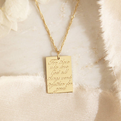 Gold chain necklace with a gold square pendant engraved with &quot;For those who love God all things work together for good&quot;, a verse of Romans 8:28