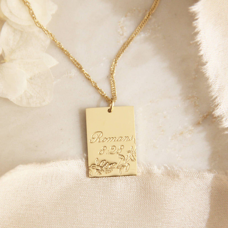 Gold chain necklace with a gold square pendant engraved with &quot;Proverbs 8:28&quot; and some leaves