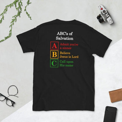 A flatlay photo of a back of a black shirt, showcasing a a Christian design, that says:
ABC&