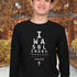 Asian man wearing a long-sleeve black Christian shirt. 

The graphic is text as an eye chart, and it says "I WAS BLIND BUT NOW I SEE".

Below the text, there is a thin line, with text "John 9:25" and an icon of a cross below.