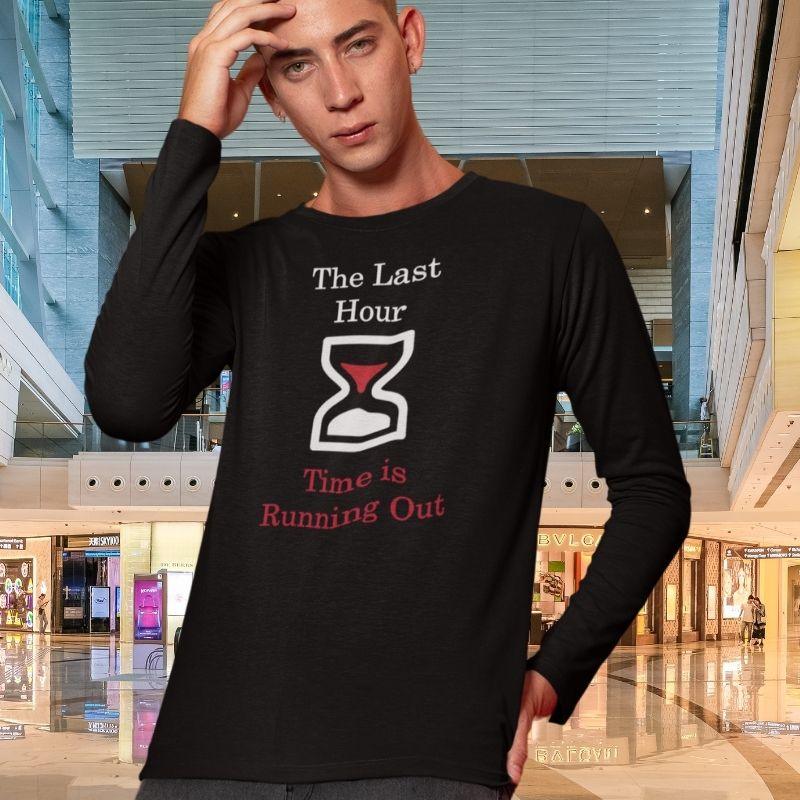 White man wearing a black Christian long-sleeve shirt. The shirt has a large hourglass icon in the middle. Above the hourglass, text says &quot;The Last Hour&quot; and below the hourglass, it says &quot;Time is Running Out&quot;.