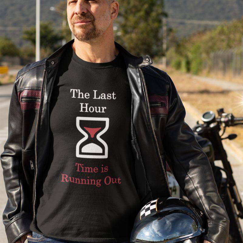 White man wearing a black Christian shirt. The shirt has a large hourglass icon in the middle. Above the hourglass, text says &quot;The Last Hour&quot; and below the hourglass, it says &quot;Time is Running Out&quot;.